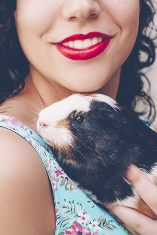 Rückenansicht einer jungen Frau mit Meerschweinchen auf der Schulter, lizenzfreies Stockfoto