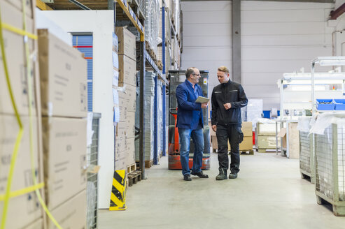 Manager und Lagerarbeiter bei der Besprechung der Logistik im Lager - DIGF000170