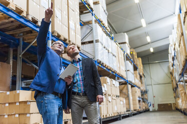 Two managers discussing packaging and shipment in storage hall - DIGF000183