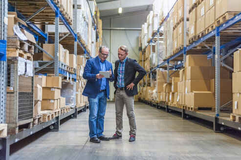 Two managers discussing packaging and shipment in storage hall - DIGF000184