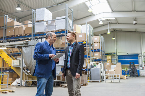 Two managers discussing packaging and shipment in storage hall - DIGF000187