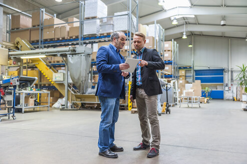 Zwei Manager besprechen Verpackung und Versand in einer Lagerhalle - DIGF000188