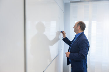 Manager im Büro schreibt auf einer weißen Tafel - DIGF000191