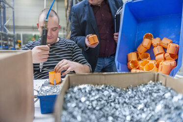 Arbeiter in der Fabrik bei der Montage von Kunststoffsteckern - DIGF000193