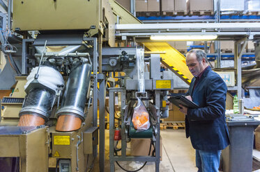 Manager bei der Kontrolle der Verpackung von Kunststoffsteckern in einer Kunststofffabrik - DIGF000195