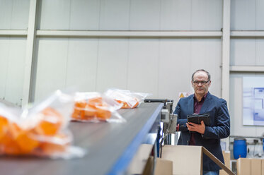 Manager, der die Verpackung von Waren in einer Kunststofffabrik kontrolliert - DIGF000199