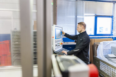 Mann arbeitet an einer Verpackungsmaschine in einer Fabrik - DIGF000233