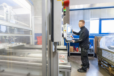 Man working at packaging machine in factory - DIGF000234