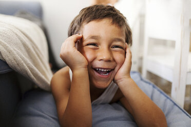 Porträt eines lachenden kleinen Jungen mit dem Kopf in den Händen - VABF000375