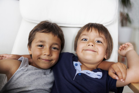 Portrait of two smiling little brothers arm in arm stock photo