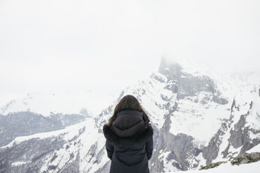Frau vor einem verschneiten Berg in den Picos de Europa - ABZF000300