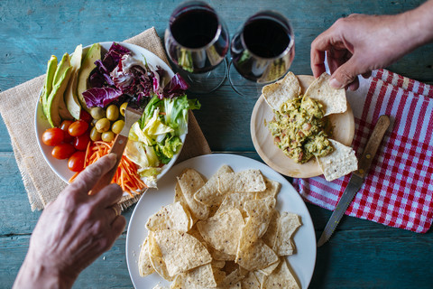 Eating nachos with guacamole and mixed salad stock photo