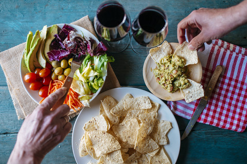 Essen von Nachos mit Guacamole und gemischtem Salat, lizenzfreies Stockfoto