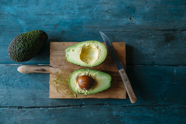 Sliced avocado on chopping board - KIJF000275