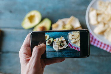 Taking a picture of nachos and guacamole with smartphone, close-up - KIJF000276