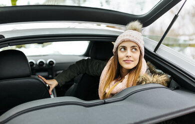 Porträt einer jungen Frau, die in einem Sportwagen sitzt - MGOF001635