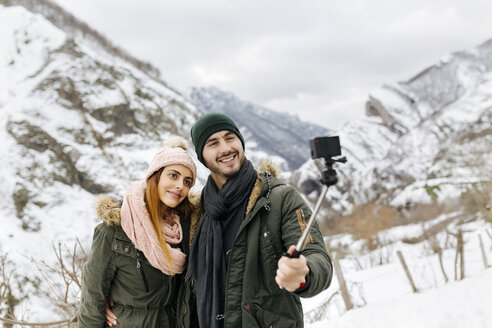 Spanien, Asturien, Paar macht Selfie in den schneebedeckten Bergen - MGOF001641