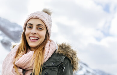 Spanien, Asturien, Porträt einer glücklichen jungen Frau in den verschneiten Bergen - MGOF001643