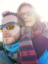 Germany, Stuttgart, portrait of young couple at backlight with reflecting of burial chapel on sunglasses - LAF001625