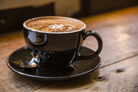 Braune Kaffeetasse auf Holz, lizenzfreies Stockfoto