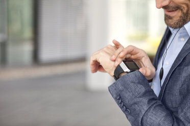 Close-up of businessman looking at smartwatch - MAEF011415