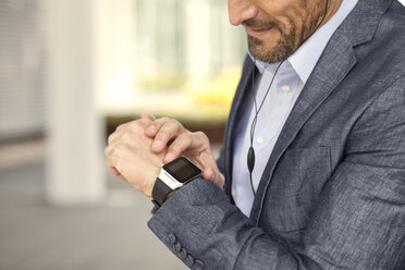 Close-up of businessman looking at smartwatch - MAEF011416