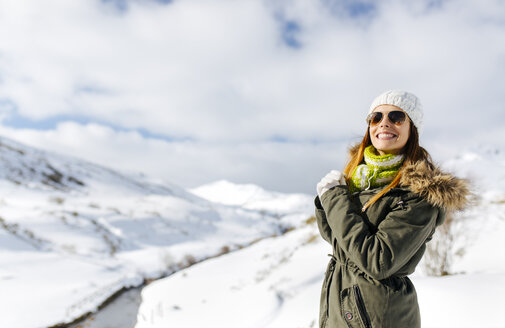 Spanien, Asturien, lächelnde junge Frau in verschneiten Bergen - MGOF001652