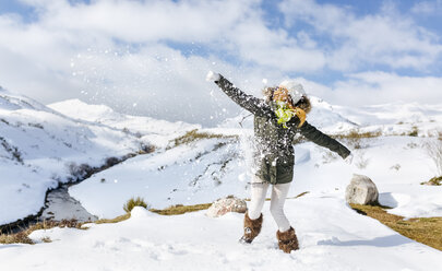 Spanien, Asturien, junge Frau spielt im Schnee - MGOF001655