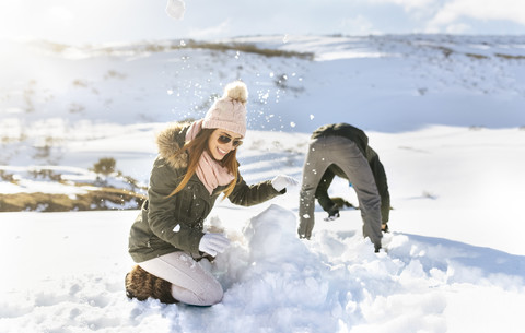 Spanien, Asturien, Paar spielt im Schnee, lizenzfreies Stockfoto