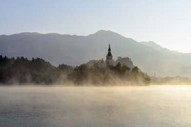 Slovenia, Gorenjska, Bled, Bled Island, Assumption of Mary's Pilgrimage Church and Lake Bled in morning fog - RUEF001673