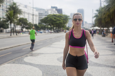 Brasilien, Rio de Janeiro, sportliche Frau läuft auf dem Bürgersteig - MAUF000371