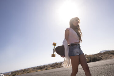 Teenager-Mädchen mit Longboard im Gegenlicht - SIPF000302