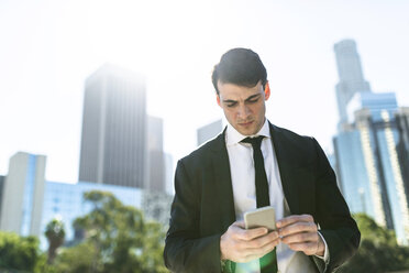 USA, Los Angeles, businessman looking at cell phone - LEF000008