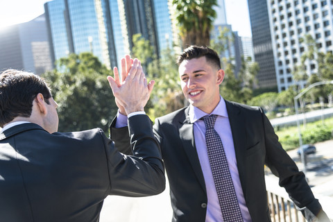 USA, Los Angeles, two businessmen high fiving stock photo