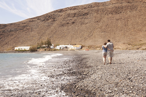 Spanien, Fuerteventura, Paar mit Baby am Strand, lizenzfreies Stockfoto