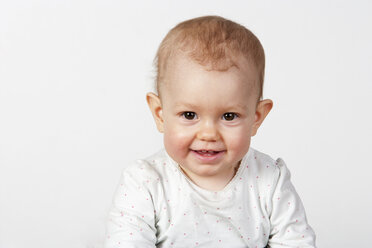 Porträt eines lächelnden kleinen Mädchens vor einem weißen Hintergrund - WWF003935