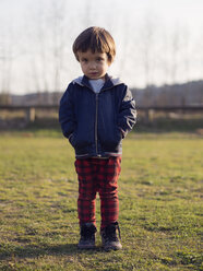 Little boy standing on grass with hands in pockets - XCF000071