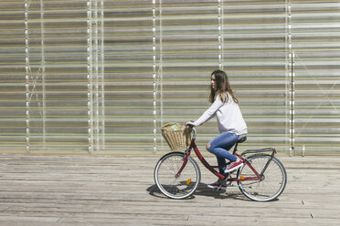 Junge Frau fährt Fahrrad mit Korb - ABZF000306