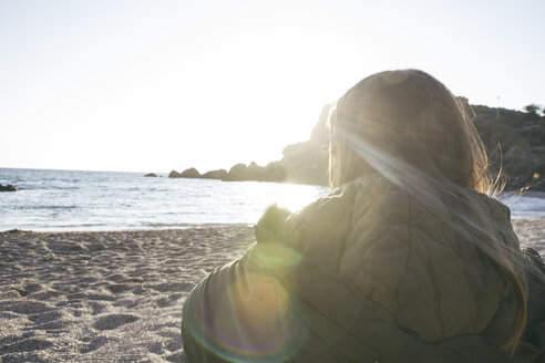 Junge Frau am Strand mit Blick aufs Meer - ABZF000307