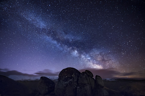 Milky way over ancient granite rocks stock photo