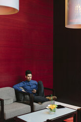 Young businessman sitting on armchair of a lobby - BOYF000228