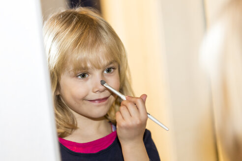 Spiegelbild eines lächelnden kleinen Mädchens, das Make-up aufträgt - JFEF000768