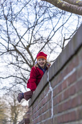 Kleines Mädchen klettert auf eine Mauer - JFEF000770