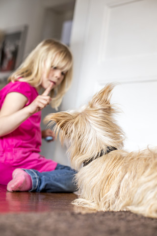 Kleines Mädchen mit ihrem Hund zu Hause, lizenzfreies Stockfoto