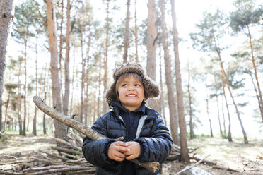 Portrait of little boy playing with branch in the woods - VABF000389