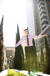 Businessman outdoors balancing on a wall - LEF000032