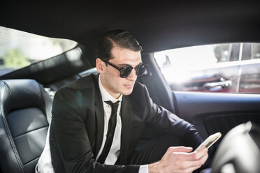 Businessman in car using cell phone - LEF000041