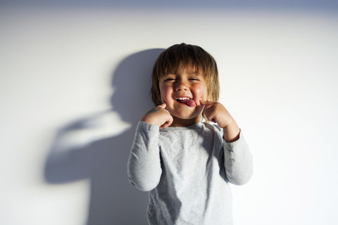 Portrait of little boy pulling funny faces stock photo