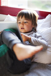 Kleiner Junge auf einer Couch mit digitalem Tablet - VABF000405