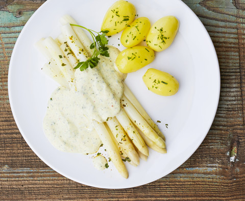 White asparagus, sauce hollandaise and boiled potatoes on plate stock photo